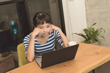 öfkeli Asya genç kadın dizüstü evde kullanma