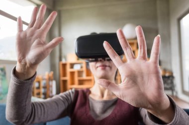 Olgun kadın evde VR kulaklık kullanarak