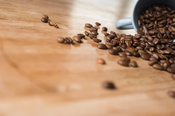 木製のテーブルの上のコーヒー豆のカップ — ストック写真
