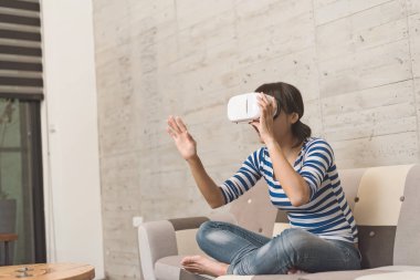 Asyalı kadın evde VR kulaklık kullanma