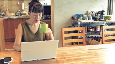 Asyalı olgun kadın dizüstü bilgisayar kullanıyor, evde çalışma kavramı