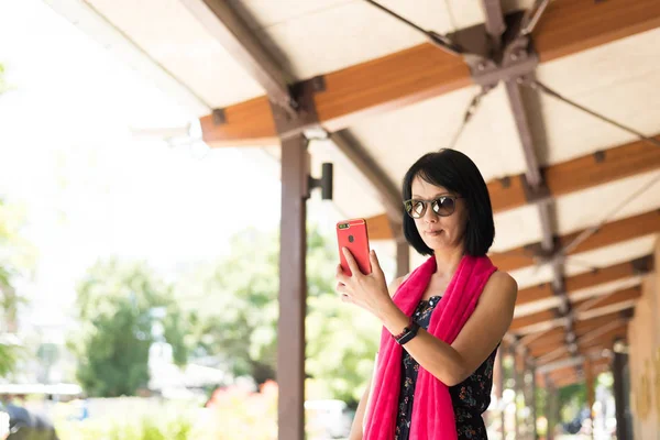 駅の廊下で携帯電話を使う女性は — ストック写真