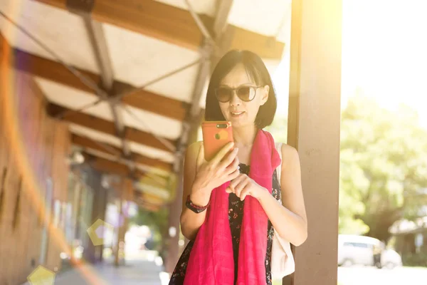 駅の廊下で携帯電話を使う女性は — ストック写真