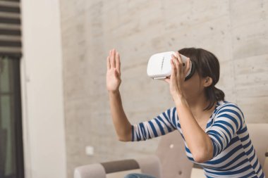 Asyalı kadın evde VR kulaklık kullanma