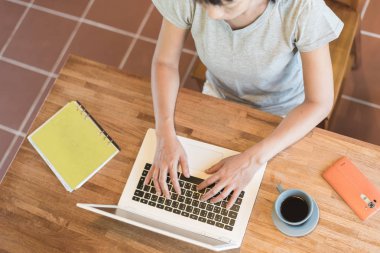 Evde kedisi masada yatarken çalışan bir kadın.
