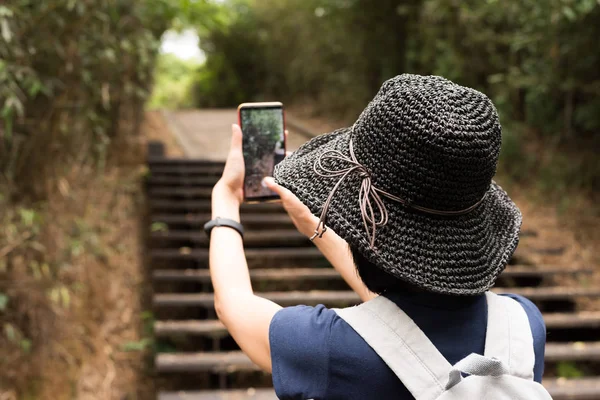 屋外でハイキングをするときに女性が写真を撮る — ストック写真