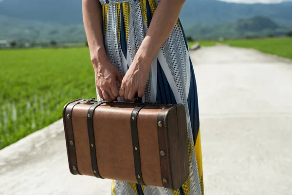 田舎の道でスーツケースを持った女性 — ストック写真