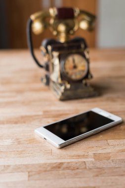 ahşap masa üzerinde yeni ve eski telefon