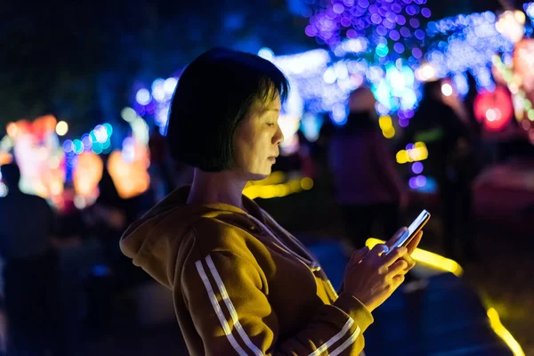 Mujer usando el teléfono celular por la noche — Foto de Stock