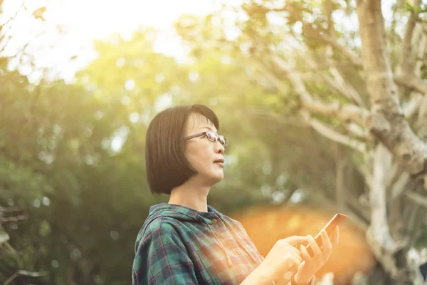 Asiatiska mogen kvinna med mobiltelefon — Stockfoto