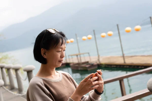 Madura mujer asiática utilizando el teléfono móvil — Foto de Stock