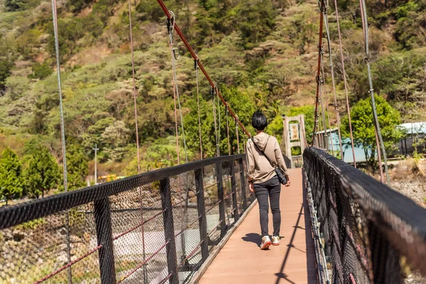 Kvinna promenad på en hängbro — Stockfoto