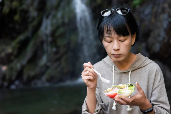 Азиатка ест салат — стоковое фото