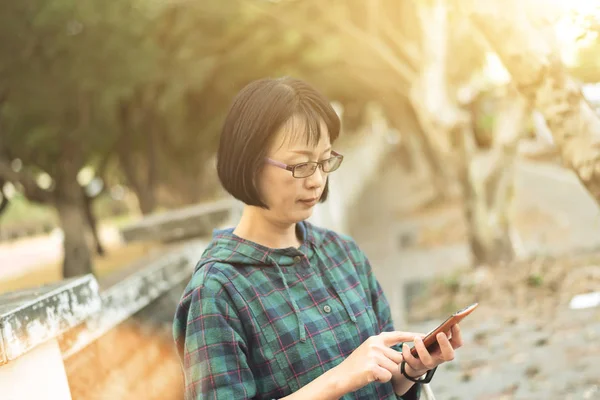 Asiatiska mogen kvinna med mobiltelefon — Stockfoto