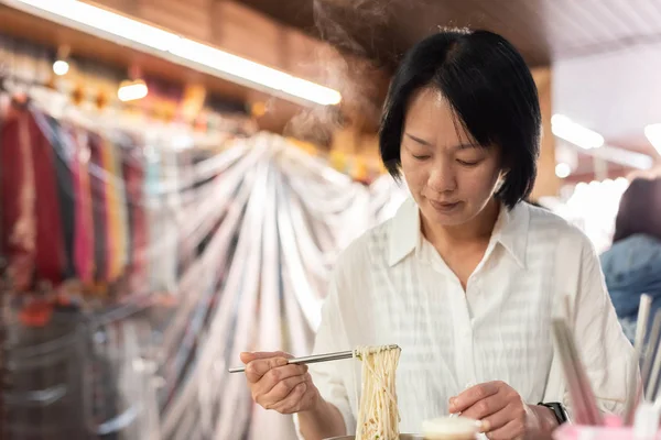Starsza kobieta azjatyckich jeść makaron — Zdjęcie stockowe