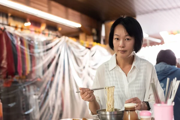 Maturo asiatico donna mangiare tagliatelle — Foto Stock