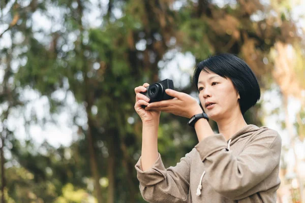 Žena držet digitální fotoaparát — Stock fotografie