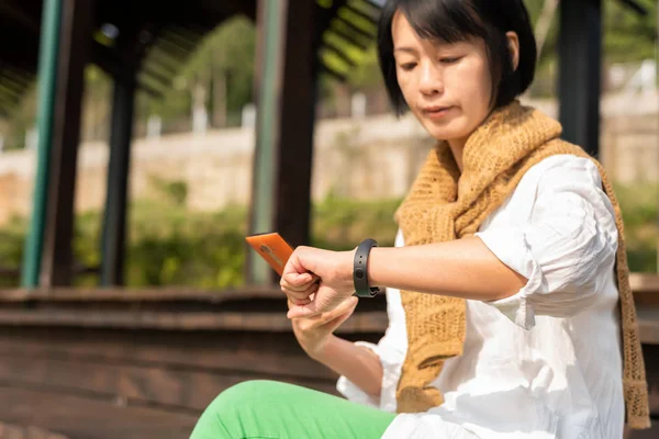 Asiatisk kvinna med smart Watch-klocka och mobile — Stockfoto
