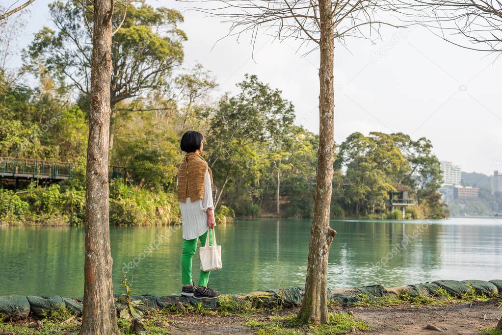 traveling Asian woman stand near the lake