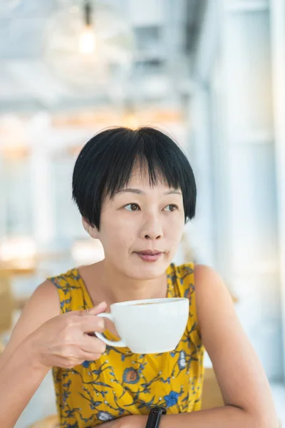 亚洲女人拿着一杯咖啡 — 图库照片