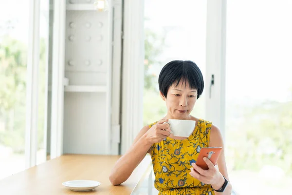 Woman using cellphone at a coffee shop — Stock Photo, Image