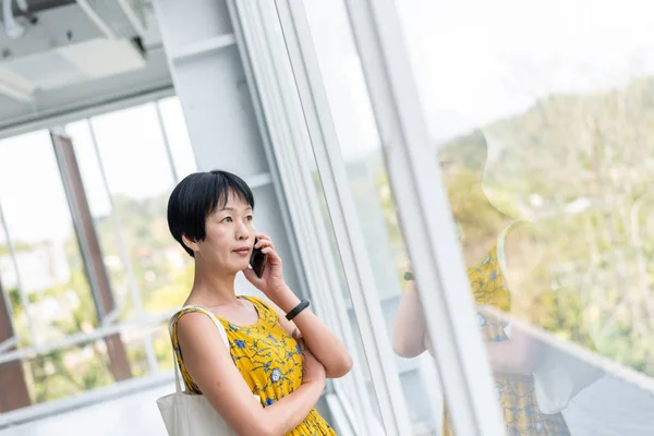Mature Asian woman talk on cellphone — Stock Photo, Image