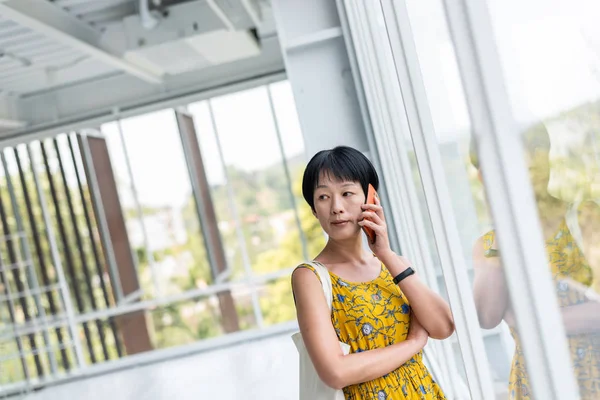 Zralá asijská ženská mluvit o mobilu — Stock fotografie