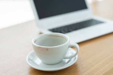 masada dizüstü bilgisayar ile kahve boş fincan