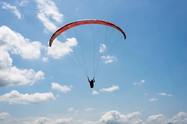 Parapente colorido sob o céu azul — Fotografia de Stock