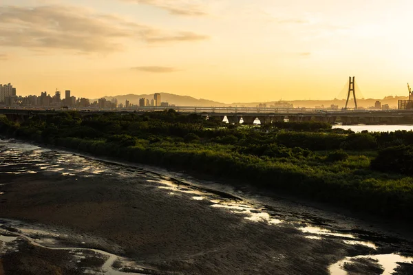 Силует будівель з річкою на заході сонця — стокове фото