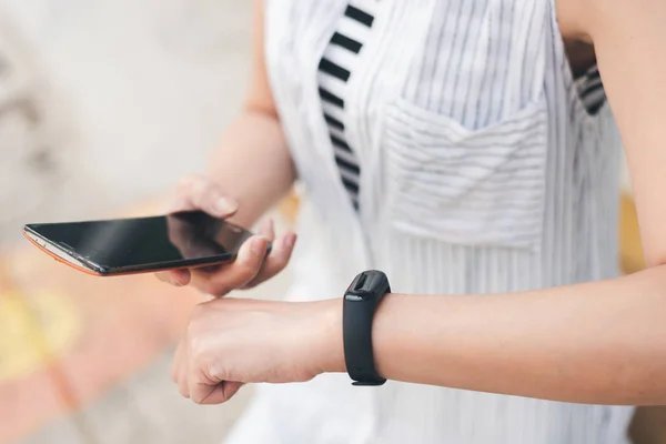 Mujer usando reloj inteligente y teléfono celular — Foto de Stock