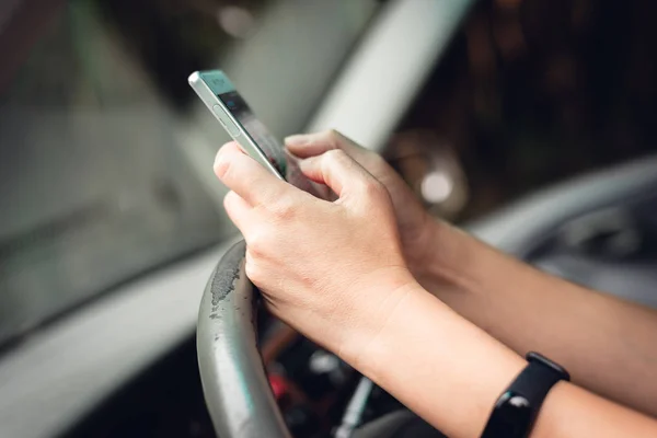 Woman using smartphone in a car — Stock Photo, Image