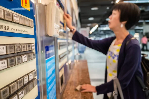 Mulher comprando na máquina de bilhetes na estação de trem — Fotografia de Stock