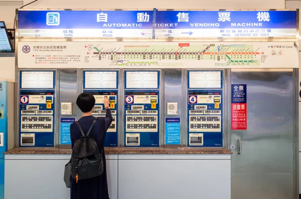 Kvinna köper på biljettautomat i tågstationen — Stockfoto
