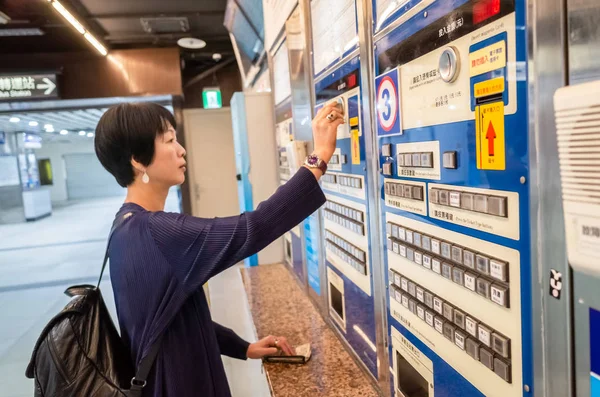 Mulher comprando na máquina de bilhetes na estação de trem — Fotografia de Stock