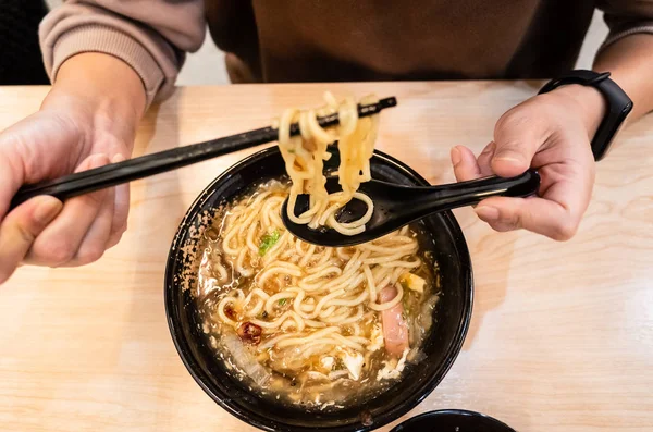 Woman eating noodles in thick soup — Stock Photo, Image