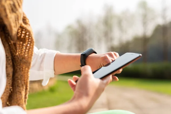 Mujer usando reloj inteligente y teléfono celular —  Fotos de Stock