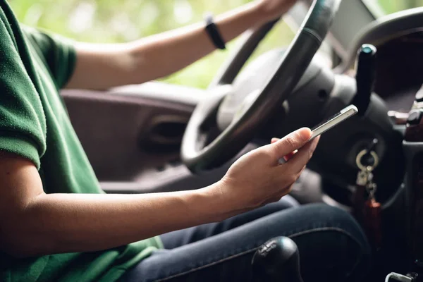 Woman using smartphone in a car — Stock Photo, Image