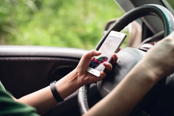 Woman using smartphone in a car — Stock Photo, Image