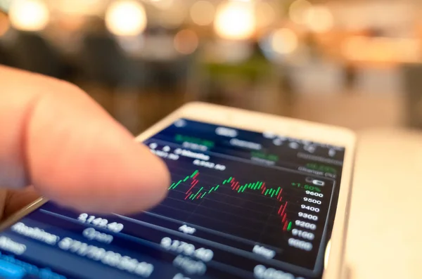 Använda en mobil enhet för att kontrollera marknadsdata — Stockfoto