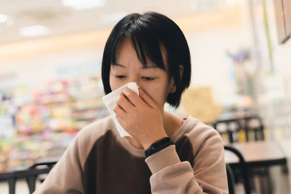 Mujer asiática se siente enferma y estornuda —  Fotos de Stock