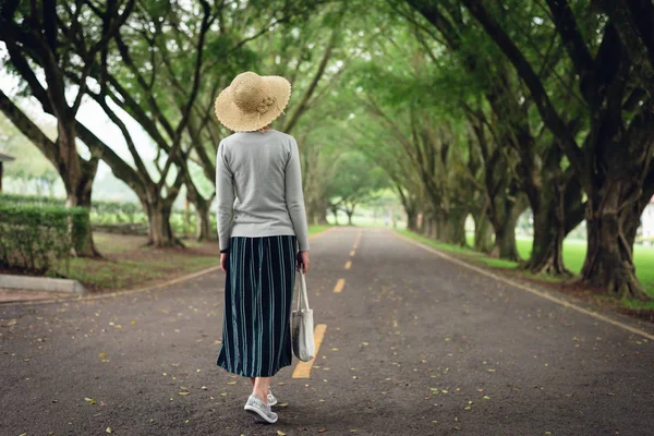 女は木の下で道を歩いていく — ストック写真