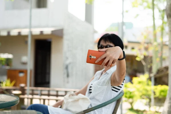 Donna sedersi e farsi un selfie — Foto Stock