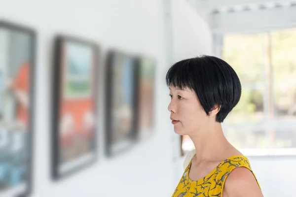 Жінка дивиться фотографію в музеї — стокове фото