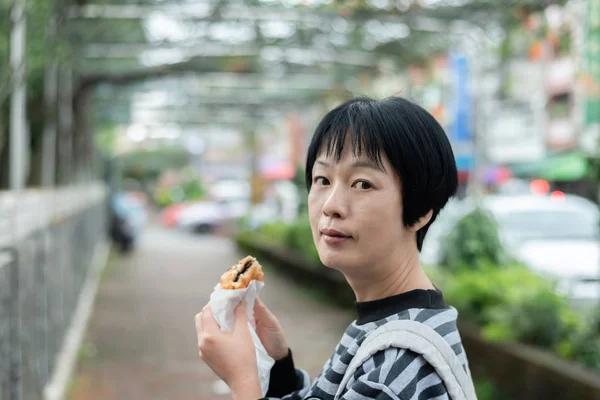 Frau isst traditionellen taiwanesischen Imbiss — Stockfoto