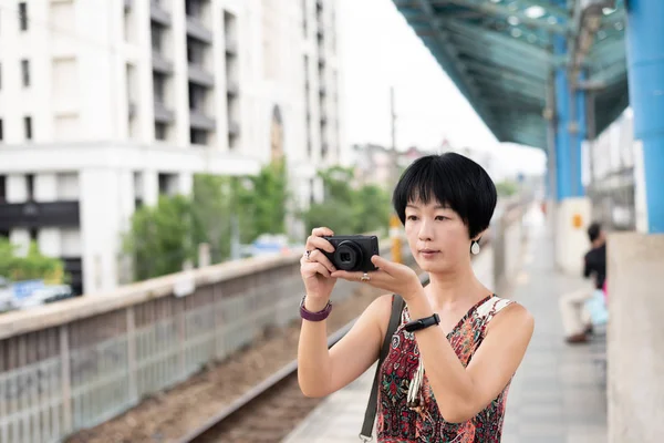 Dospělá asijská žena používající digitální fotoaparát — Stock fotografie