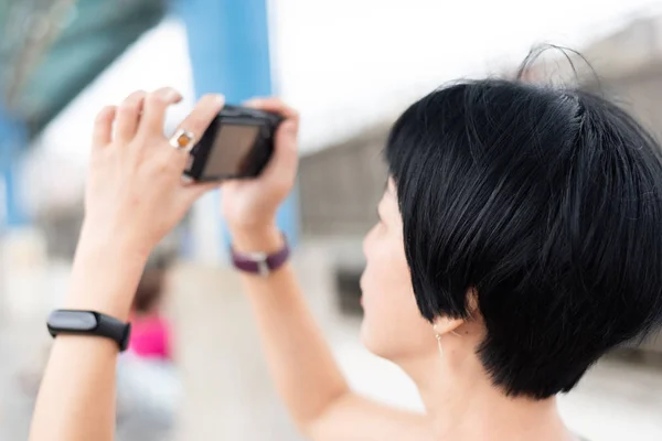 Volwassen Aziatische vrouw met behulp van digitale camera — Stockfoto