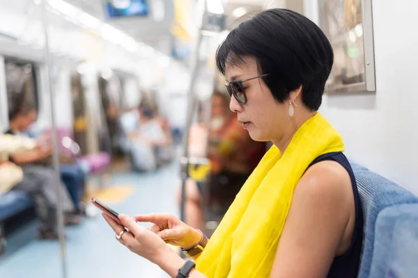 Woman using smartphone at the MRT carriage — Stock Photo, Image