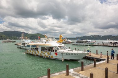 Xuanguang tapınak iskelesinde turistler ve tekneler