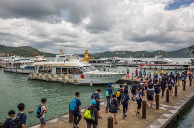 Xuanguang tapınak iskelesinde turistler ve tekneler